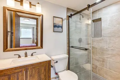 a bathroom with a shower and a toilet and a sink at Cozy Condo Steps to Free Winter Park Shuttle! in Fraser
