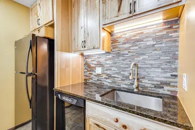 a kitchen with a sink and a refrigerator at Cozy Condo Steps to Free Winter Park Shuttle! in Fraser