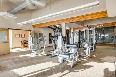 a gym with several tread machines in a room at Cozy Condo Steps to Free Winter Park Shuttle! in Fraser