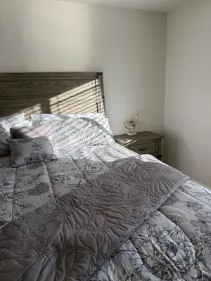 a bedroom with a large bed with a wooden headboard at Bsnsn in Commerce City