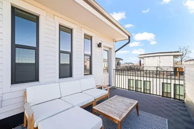 a balcony with a white couch and a table at Bright 1BR Office, Attached Garage & Fast WiFi in Denver