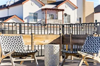 a wooden bench and two chairs in front of a fence at Bright 1BR Office, Attached Garage & Fast WiFi in Denver