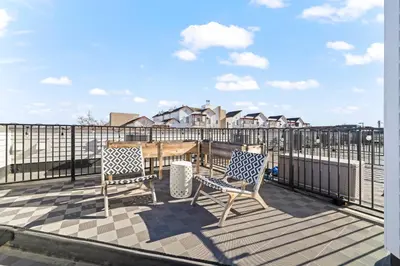 a balcony with two chairs and a table and a fence at Bright 1BR Office, Attached Garage & Fast WiFi in Denver