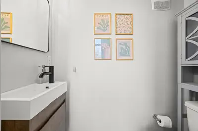 a bathroom with a sink and a mirror at Bright 1BR Office, Attached Garage & Fast WiFi in Denver