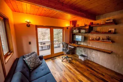 a living room with a blue couch and a desk at The Rusty Skillet Spa and Ranch in Boulder