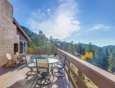 a patio with a table and chairs on a deck at Rocky Mountain Panorama Cabin in Estes Park