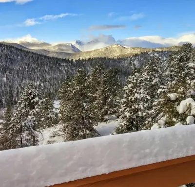 a view of the snow covered trees and mountains at Rocky Mountain Panorama Cabin in Estes Park