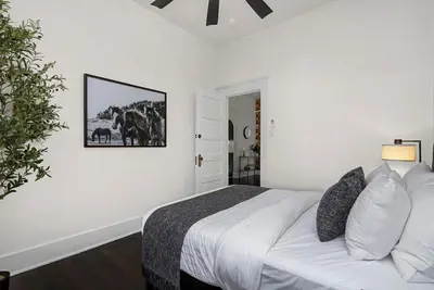 a white bedroom with a bed and a picture on the wall at The Wild Peony Walk to Old Town FC and CSU Campus in Fort Collins