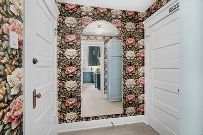 a mirror in a hallway with floral wallpaper at The Wild Peony Walk to Old Town FC and CSU Campus in Fort Collins