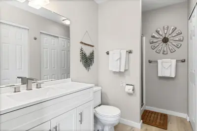 a white bathroom with a sink and a toilet at Chimney Park Retreat King Suite and Fenced Yard in Windsor