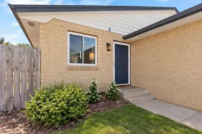 a brick house with a fence and a door at Chimney Park Retreat King Suite and Fenced Yard in Windsor