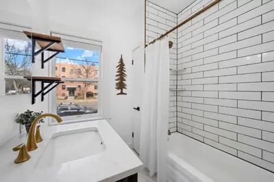 a white bathroom with a tub and a window at Campus Corner Retreat Two King Beds and Dog Friendly in Fort Collins