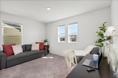 a living room with a couch and a table with a laptop at Pelican Landing Modern 3BD in Lakes at Centerra in Loveland
