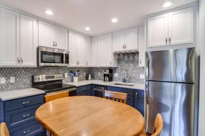 a kitchen with a wooden table and a refrigerator at 3 Mi to Slopes! Family-Friendly Winter Park Escape in Winter Park