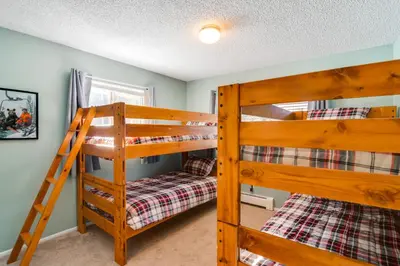 two bunk beds in a room with a ladder at 3 Mi to Slopes! Family-Friendly Winter Park Escape in Winter Park