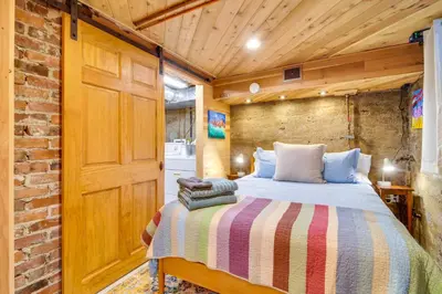 a bedroom with a bed and a brick wall at Explore CU! Unique Studio with Private Courtyard in Boulder