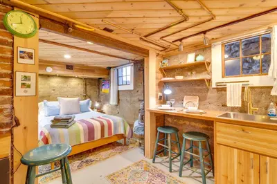 a bedroom in a tiny house with a bed and a kitchen at Explore CU! Unique Studio with Private Courtyard in Boulder