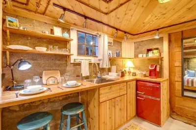 a kitchen with wooden cabinets and a counter with stools at Explore CU! Unique Studio with Private Courtyard in Boulder