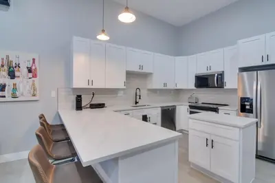 a white kitchen with white cabinets and a refrigerator at Steps to Casinos and Shuttle! Central City Home Base in Central City