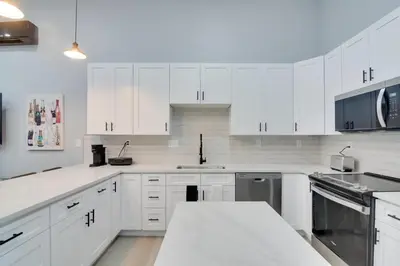 a white kitchen with white cabinets and a counter top at Steps to Casinos and Shuttle! Central City Home Base in Central City