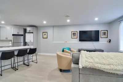 a living room with a couch and chairs and a kitchen at Walkable Townhome in the Heart of Central City! in Central City