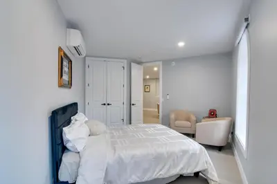 a white bedroom with a bed and a living room at Walkable Townhome in the Heart of Central City! in Central City