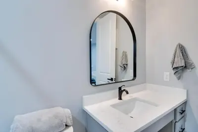 a bathroom with a white sink and a mirror at Walkable Townhome in the Heart of Central City! in Central City