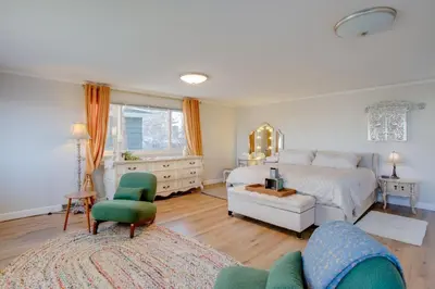 a bedroom with a white bed and a green chair at 2 Mi to Old Town Pet-Friendly Home Base in Arvada in Arvada