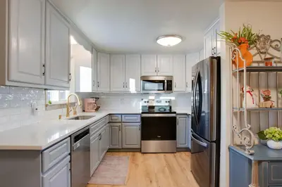a kitchen with white cabinets and a stainless steel refrigerator at 2 Mi to Old Town Pet-Friendly Home Base in Arvada in Arvada
