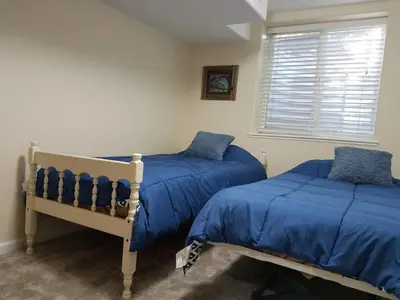 two beds in a bedroom with blue sheets and a window at Renovated 2BR flat near Red Rocks-Rocky Mt-DT-15min in Golden