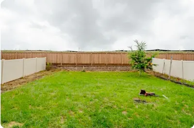 a backyard with a fence and a green yard at Comfort stay near Denver airport in DEN