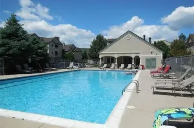 a large swimming pool with chairs and a house at Bright Airy Home with Scenic Views in Littleton