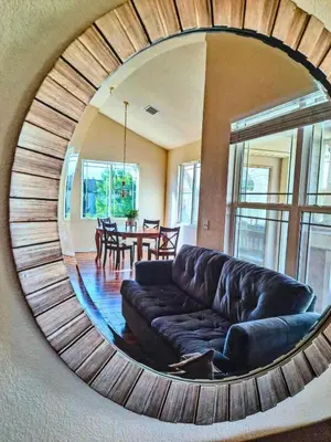 a circular mirror in a living room with a couch at Bright Airy Home with Scenic Views in Littleton