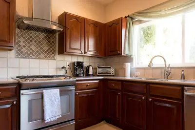a kitchen with wooden cabinets and a stove top oven at Spacious Single Family Home in the Heart of Denver in Denver