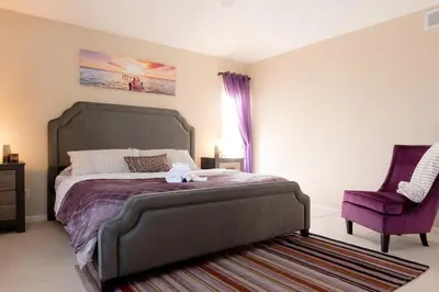 a bedroom with a large bed and a purple chair at Spacious Single Family Home in the Heart of Denver in Denver