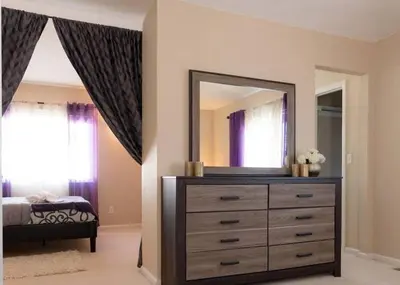 a bedroom with a dresser and a large mirror at Spacious Single Family Home in the Heart of Denver in Denver