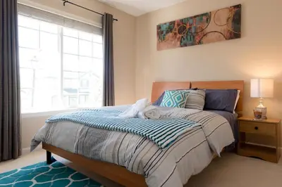 a bedroom with a bed and a large window at Spacious Single Family Home in the Heart of Denver in Denver