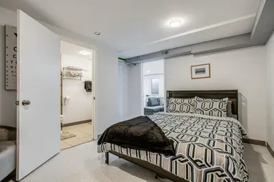 a bedroom with a large bed and a bathroom at Hot Tub, Fire Pit! Group-Ready Stay Near Denver in Commerce City