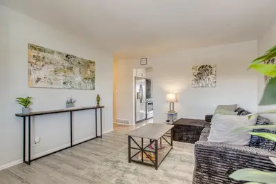a living room with a couch and a table at Hot Tub, Fire Pit! Group-Ready Stay Near Denver in Commerce City