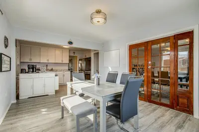 a kitchen and dining room with a table and chairs at Hot Tub, Fire Pit! Group-Ready Stay Near Denver in Commerce City