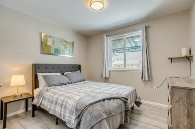 a bedroom with a bed and a window at Hot Tub, Fire Pit! Group-Ready Stay Near Denver in Commerce City