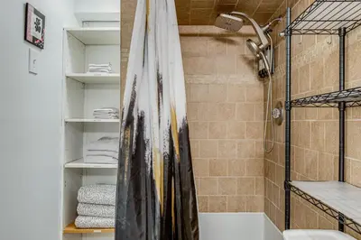 a bathroom with a shower with a shower curtain at Hot Tub, Fire Pit! Group-Ready Stay Near Denver in Commerce City