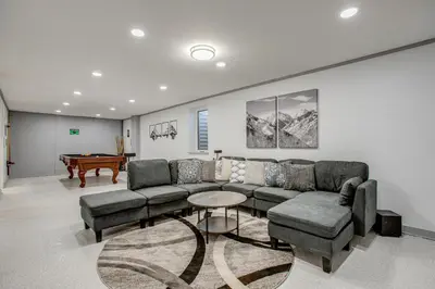 a living room with a couch and a table at Hot Tub, Fire Pit! Group-Ready Stay Near Denver in Commerce City