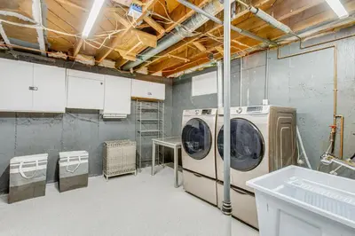 a laundry room with a washer and dryer in it at Hot Tub, Fire Pit! Group-Ready Stay Near Denver in Commerce City