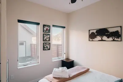 a white bedroom with two windows and a bed at Lakefront - Trails - Skiing - Views - Georgetown in Georgetown