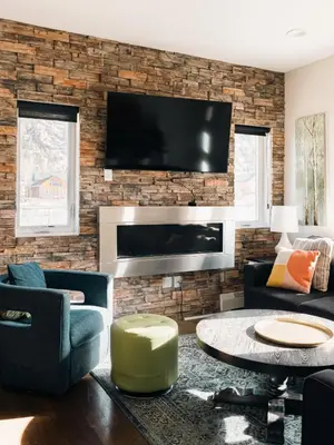 a living room with a tv on a brick wall at Lakefront - Trails - Skiing - Views - Georgetown in Georgetown