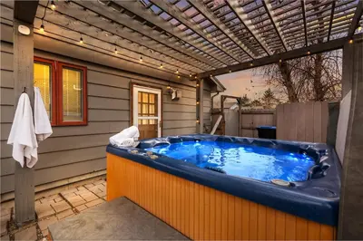 a hot tub in a backyard with a pergola at HotTub - Big Yard - Fireplaces - Games - Fire pit in Arvada
