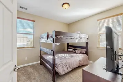 a bedroom with a bunk bed and a desk with a computer at Timbers at the Pines in Fraser