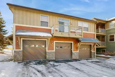 a house with two garage doors in the snow at Timbers at the Pines in Fraser