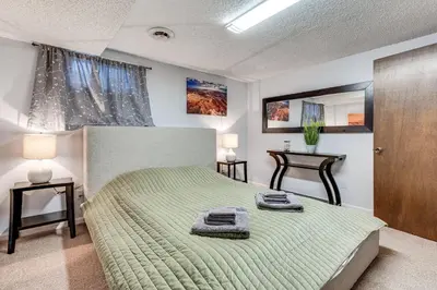 a bedroom with a green bed with two towels on it at Cozy Boulder Basement Unit Upscale Outdoor Space! in Boulder